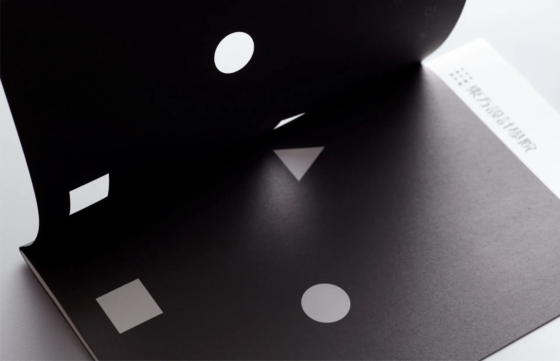 手冊以點、線、面方式，貫穿「設計美學‧國際宏觀」的概念，再以幾何圖形的正方形代表著規矩、三角形代表著磨練、圓形代表著融合