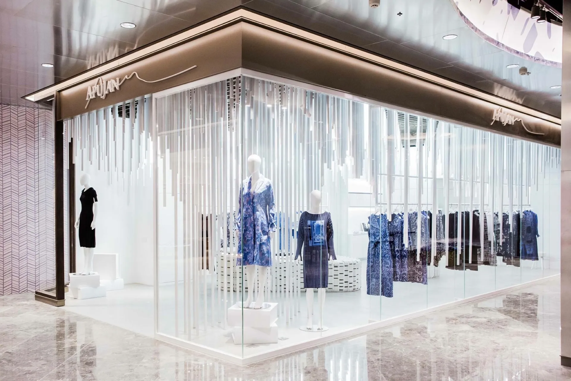 空間設計上以數位模擬布料因重力下垂的曲面去圍繞出空間的神祕感，材質和顏色上反向使用了大量純白烤漆鋁條混合訂製的白色LED燈具讓空間雖然神秘但在使用上卻很鮮明的襯托APUJAN的作品，在設計手法上盡量維持空間的純粹性，讓每一季的服裝和每一位消費者在這個空間中就是主角。